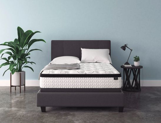 white mattress on a black bed base in a studio bedroom with blue walls